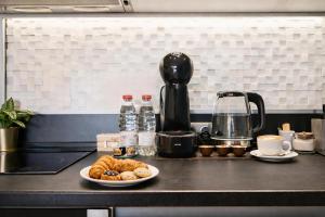 a table with a plate of pastries and a coffee maker at N9 Studentski Loft - Cozy Apt with Private Parking in Sofia +9 photos