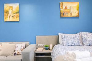a blue room with a bed and a couch at N9 Studentski Loft - Cozy Apt with Private Parking in Sofia