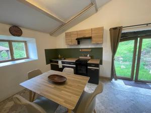a kitchen with a wooden table and a dining room at Gîte des Nicolaux in Beauvène