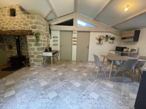 a living room with a table and a stone fireplace at Gîte des Nicolaux in Beauvène +10 photos