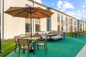 a patio with tables and chairs and an umbrella at Best Western Courtview Hotel in Springfield