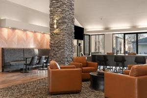 a lobby with chairs and a bar in the background at Best Western Courtview Hotel in Springfield
