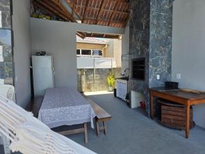 a room with a bed and a table and a kitchen at Casa com piscina Itapoá Itapema do Norte in Itapoa