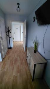 a living room with a tv and a wooden floor at Blues Hostel in Konin