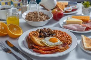 a table with plates of breakfast food on it at Best Western The Plough Hotel in Northampton +60 photos