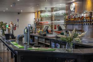 a bar in a restaurant with a counter at Best Western The Plough Hotel in Northampton