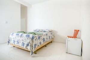 a bedroom with a bed and a wooden chair at Casa de Gil do Pão in Lençóis