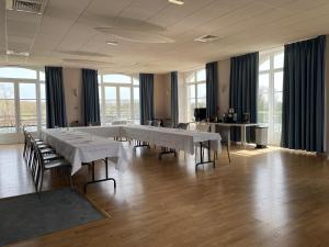 a large room with tables and chairs and windows at Le Moulin de Moissac, Sure Hotel Collection by Best Western in Moissac