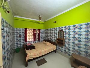 a bedroom with a bed and a green wall at Jagannath Guest House in Navadwīp +53 photos