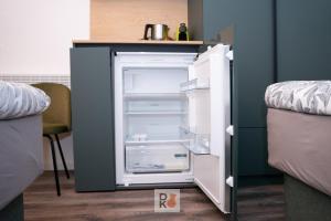 an empty refrigerator with its door open in a room at Studio-Apartament 101 free Parking Domus Kushal in Viersen