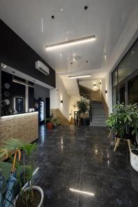 a lobby with potted plants and stairs in a building at Forsage Hotel in Uzhhorod