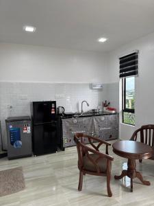 a kitchen with a table and a stove and a table at GG Studio in Kampong Sura