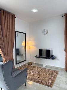 a living room with a chair and a mirror at GG Studio in Kampong Sura