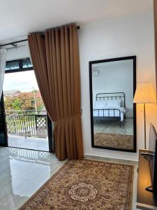 a living room with a bed and a large mirror at GG Studio in Kampong Sura