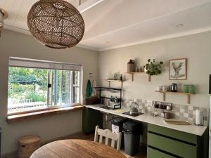 a kitchen with a counter and a table and a window at Meander Stay Clarens in Clarens +25 photos
