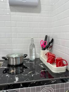 a counter top with a pot and a tray with scissors at GG Studio in Kampong Sura