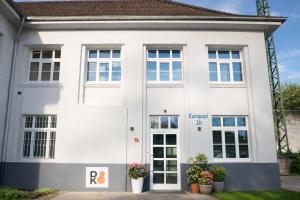 a white house with windows and plants in front of it at Studio-Apartament 101 free Parking Domus Kushal in Viersen