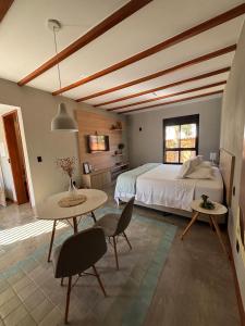 a bedroom with a bed and a table and chairs at Confraria da Prata Flats in Pirenópolis +118 photos
