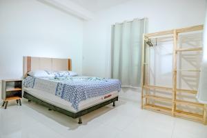 a white bedroom with a bed and a window at Casa de Gil do Pão in Lençóis