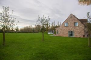 a brick house in a green field with trees at 'Op de Borgt' met Finse Grill Kota in Wellen