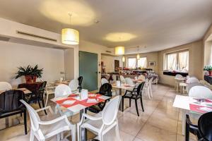 a restaurant with white tables and white chairs at HOTEL HMR RHO Milano in Rho