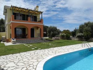 a villa with a swimming pool in front of a house at Villa Stamata in Tsoukalades