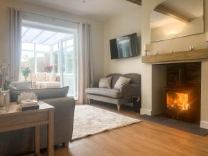 a living room with a couch and a fireplace at Garth Cottage in Keswick