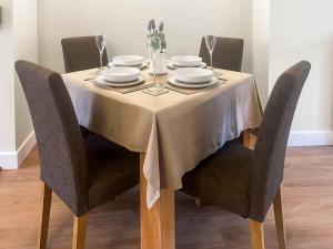 a dining room table with a white table cloth on it at Garth Cottage in Keswick