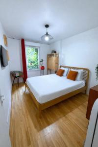 a bedroom with a large white bed and a window at Passion et détente by UTA HOUSE in Saint-Denis