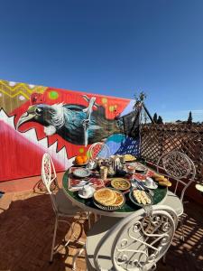 a table with food on it with a mural at Riad R Art in Marrakesh