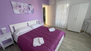 a bedroom with a purple bed with two towels on it at Fior di Luna in Stresa