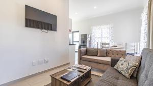 a living room with a couch and a tv on a wall at Cozy Cove St Helena in West Point