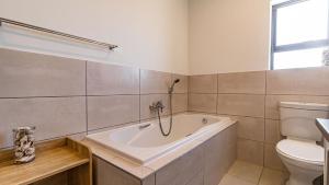 a bathroom with a bath tub and a toilet at Cozy Cove St Helena in West Point +74 photos
