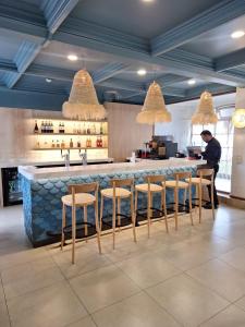 a man standing at a bar in a restaurant at Hotel La Serena - Caja Los Andes in La Serena