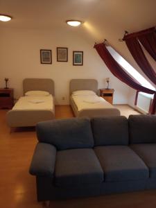 a living room with two beds and a couch at Penzion Scarlet in Trenčín +6 photos