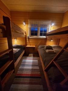 a small room with two bunk beds and a window at Aurora Lodge Helligskogen with sauna in Helligskogen