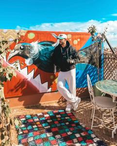 a man standing in front of a wall with a mural at Riad R Art in Marrakesh