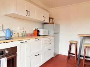 a kitchen with white cabinets and a refrigerator at L'Authentic - Appartement spacieux in Villeneuve-sur-Yonne +2 photos