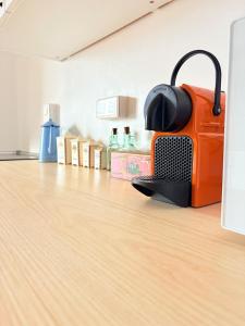 an orange toaster sitting on top of a wooden floor at L'Authentic - Appartement spacieux in Villeneuve-sur-Yonne