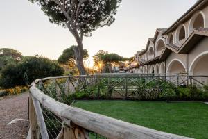 a wooden fence in front of a building with a green yard at Borgo Del Navigatore in Marina di Grosseto