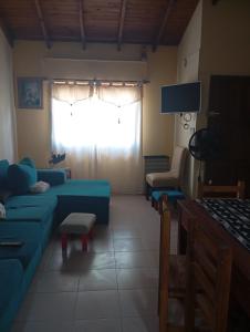 a living room with a blue couch and a window at lo de Jor in Quequén
