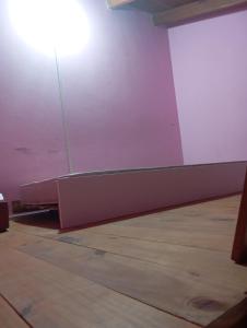 an empty room with a light on the wall and a wooden floor at lo de Jor in Quequén