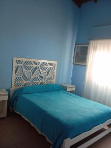 a blue bedroom with a bed and a window at lo de Jor in Quequén