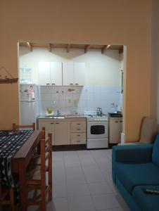 a kitchen with a table and a blue couch at lo de Jor in Quequén