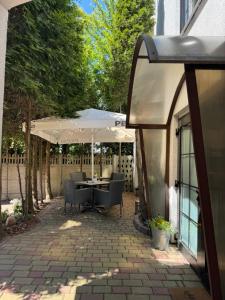 a patio with a table and an umbrella at Domek Mustang in Bytom