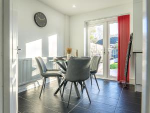 a dining room with a table and chairs and a clock at Cranberry House Stylish 3BR, 7 Guests Contractor with Cinema Room Near JLR NEC and Airport in Sheldon