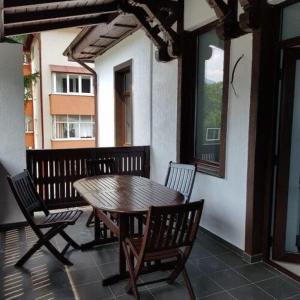 a wooden table and chairs sitting on a porch at White Wood Chalet in Buşteni