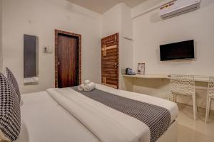 a bedroom with a bed and a desk and a television at Urban Villa ,Baner in Pune +18 photos