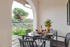 a dining room with a table and chairs and a window at Borgo Del Navigatore in Marina di Grosseto +52 photos