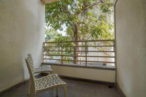 a balcony with two chairs and a tree at Urban Villa ,Baner in Pune